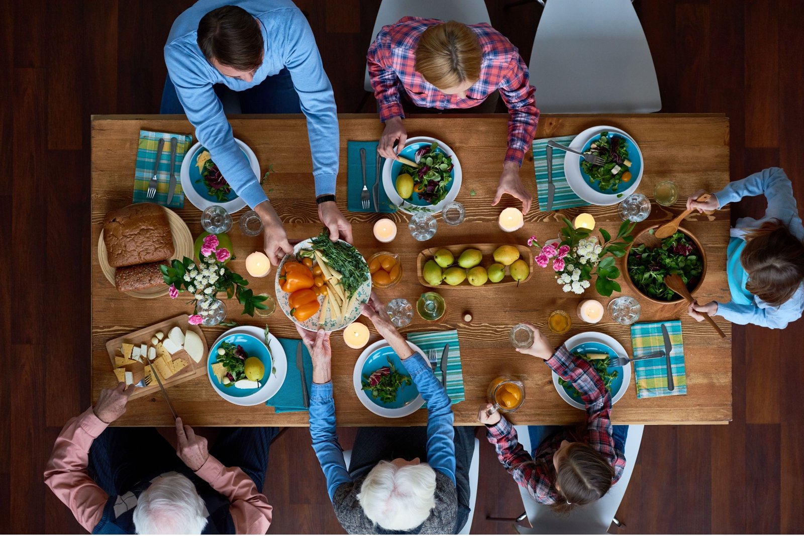 Family gathered around a full dinner table seen from above